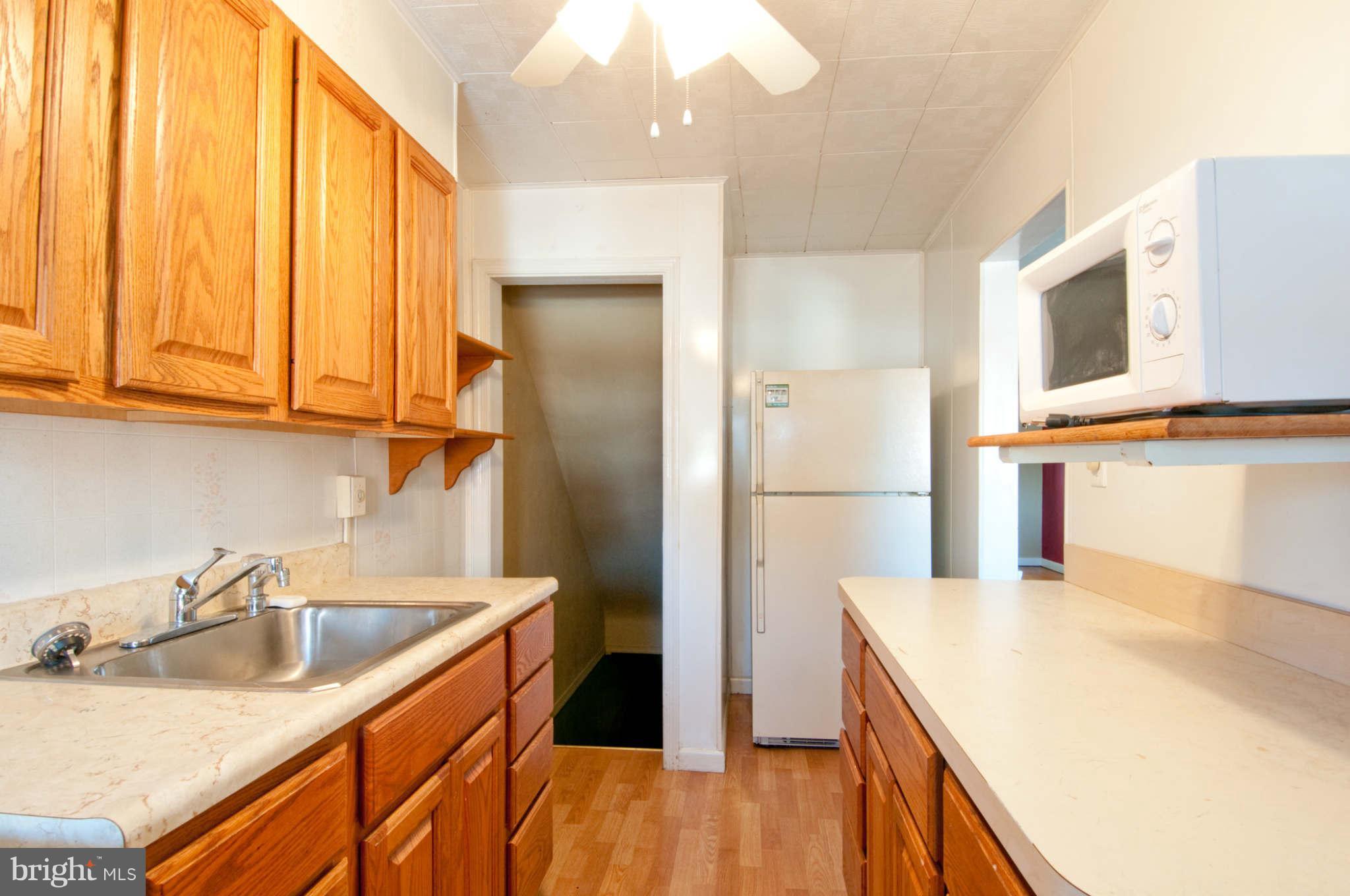 422 Westfield Road Baltimore, MD 21222 - Photo 9 of 24 a kitchen with a sink a refrigerator and cabinets