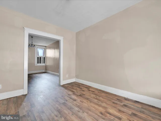 an empty room with wooden floor and mirror