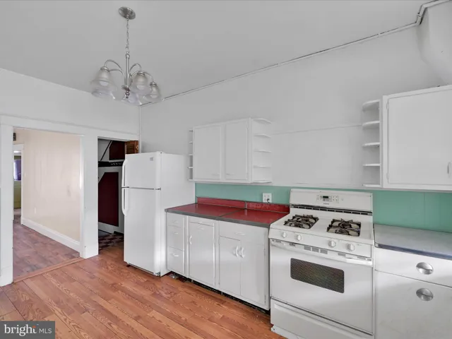 a kitchen with a stove a refrigerator and a window
