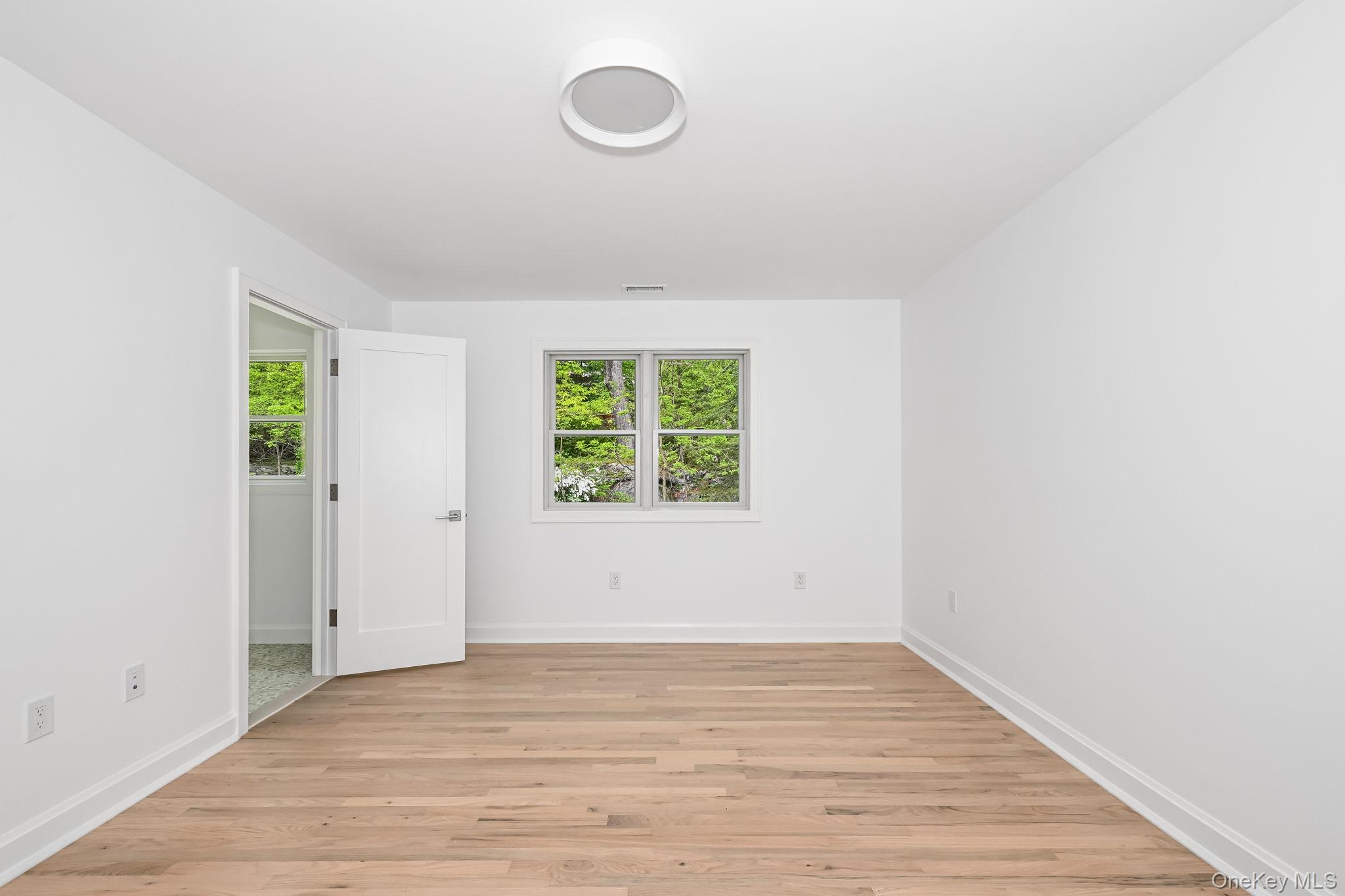 24 Country Road Mamaroneck, NY 10543 - Photo 26 of 37 a view of an empty room with wooden floor and a window