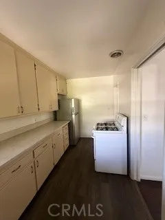 a kitchen with granite countertop a refrigerator a sink and dishwasher with wooden floor