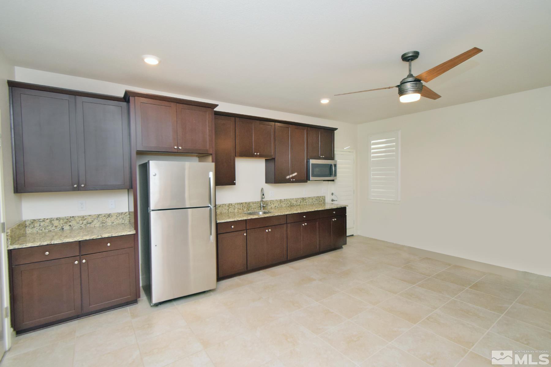 1630 Scott Valley Road Reno, NV 89523 - Photo 29 of 33 a kitchen with granite countertop a refrigerator a sink and wooden cabinets