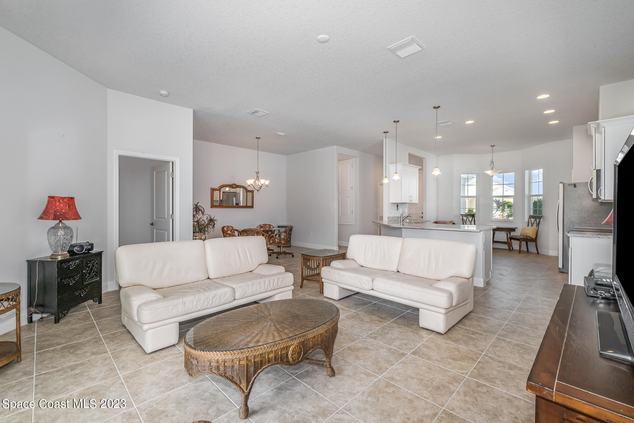 665 Lorelei Avenue Melbourne, FL 32901 - Photo 16 of 32 a living room with furniture and a dining table with kitchen view