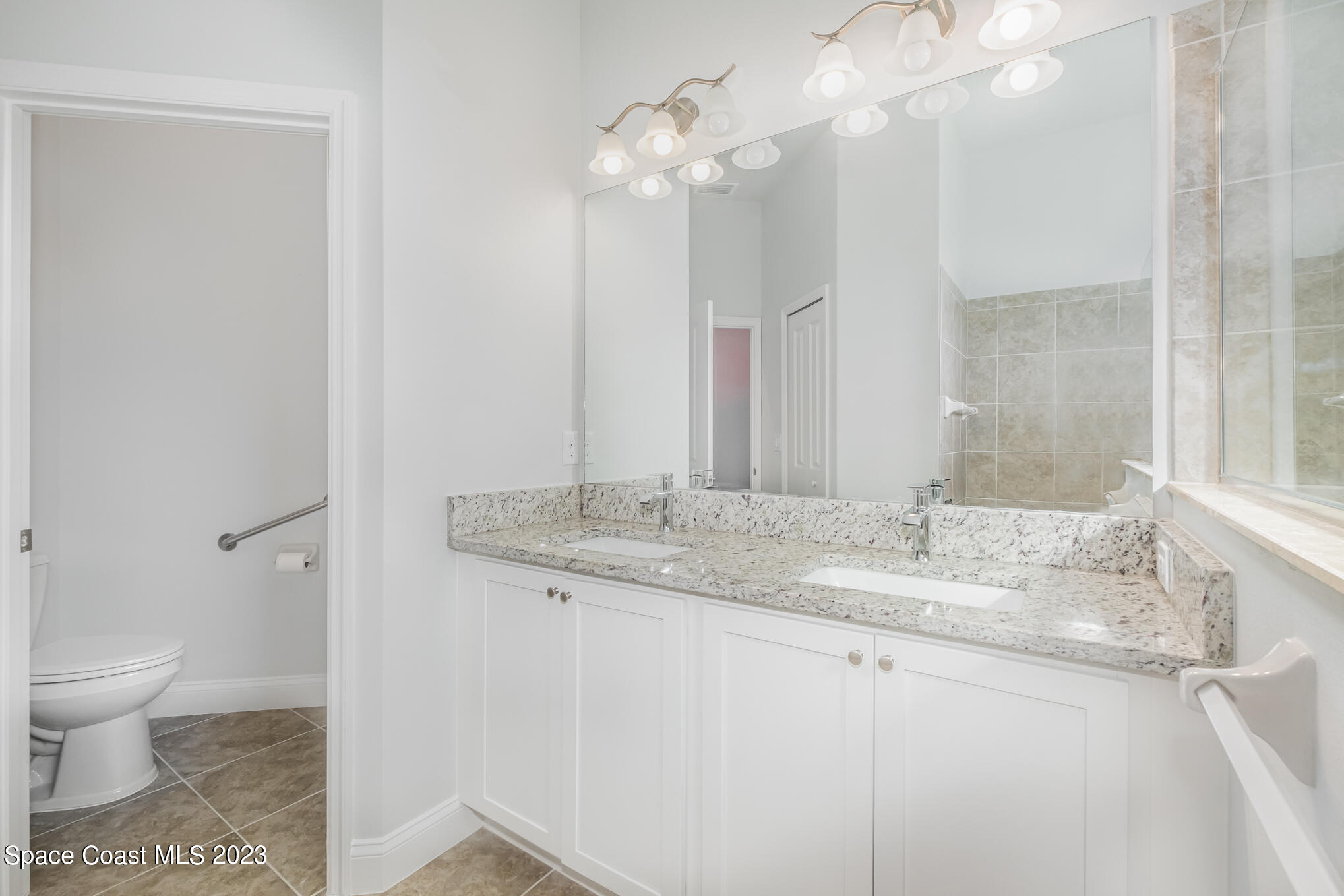 665 Lorelei Avenue Melbourne, FL 32901 - Photo 26 of 32 a bathroom with a granite countertop sink a toilet and a mirror
