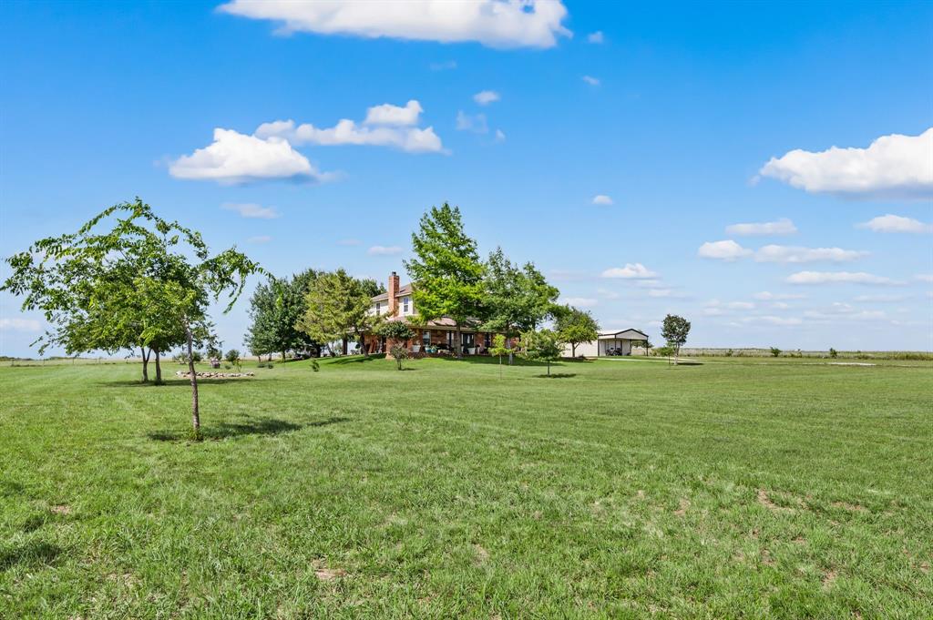 2141 Old Denton Road Decatur, TX 76234 - Photo 36 of 40 Expansive property featuring a large grassy field, distant residence, separate outbuilding, and scattered mature trees