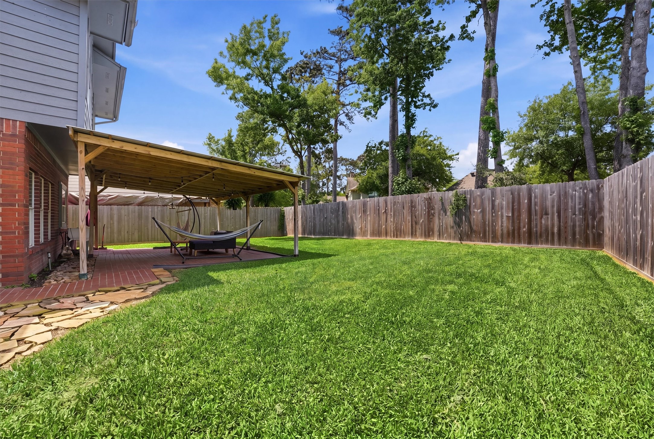 8827 Mile Run Road Humble, TX 77346 - Photo 27 of 37 a view of backyard with table and chairs and a large tree