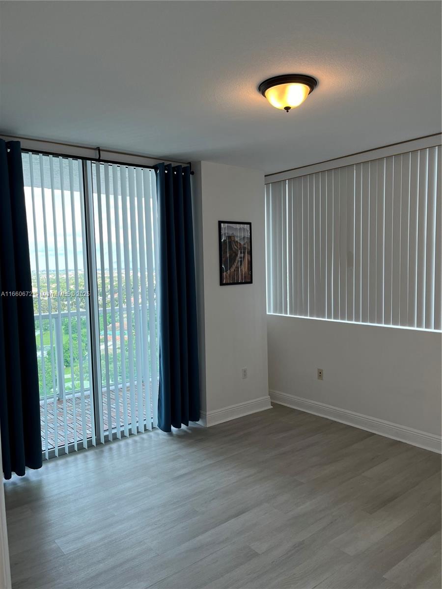 2681 North Flamingo Road, Unit 2108S Sunrise, FL 33323 - Photo 11 of 20 an empty room with wooden floor and windows