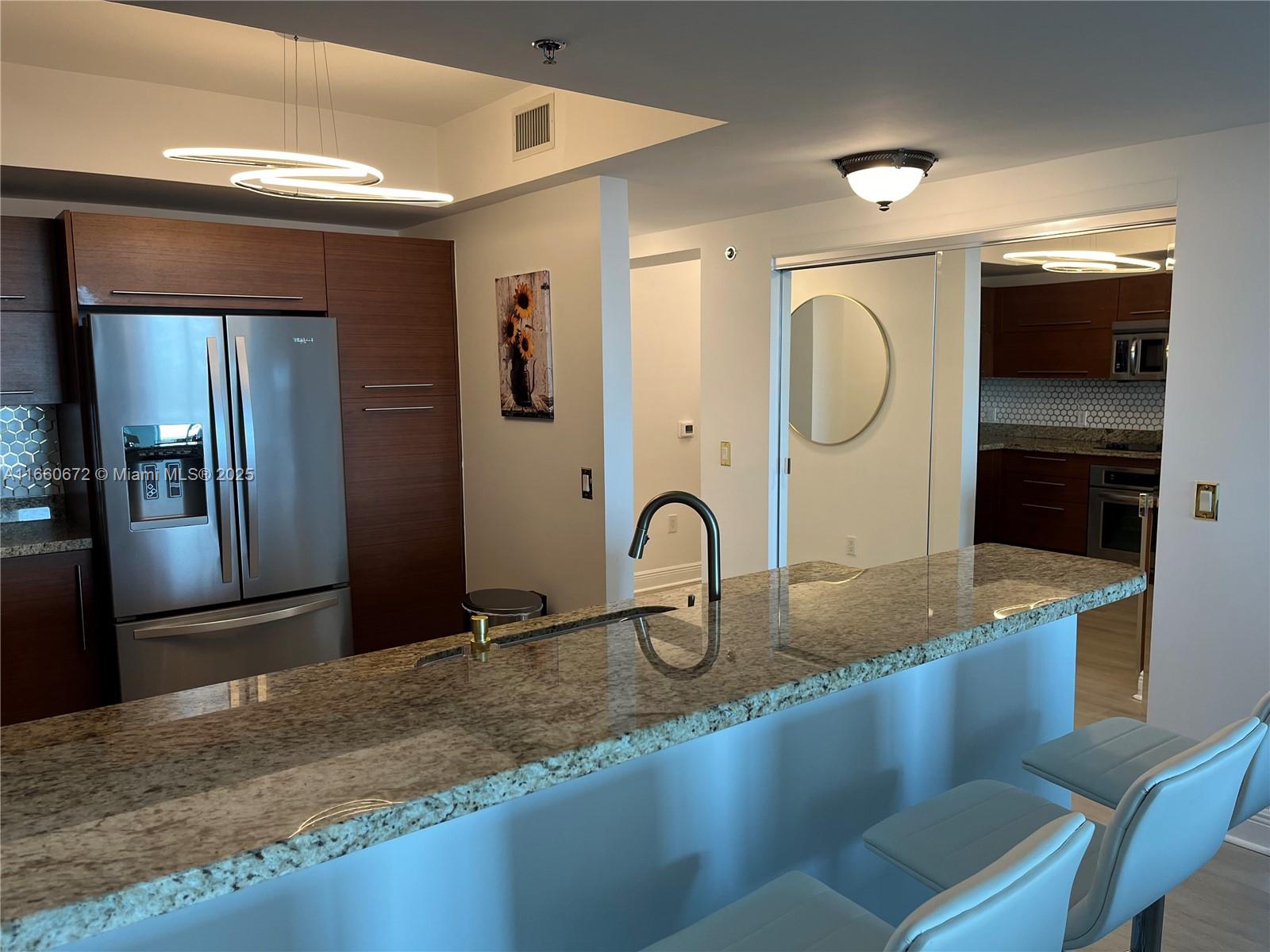 2681 North Flamingo Road, Unit 2108S Sunrise, FL 33323 - Photo 7 of 20 a kitchen with granite countertop a sink and a stove top oven