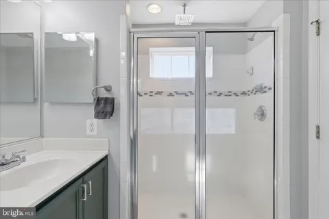 a bathroom with a shower sink and mirror