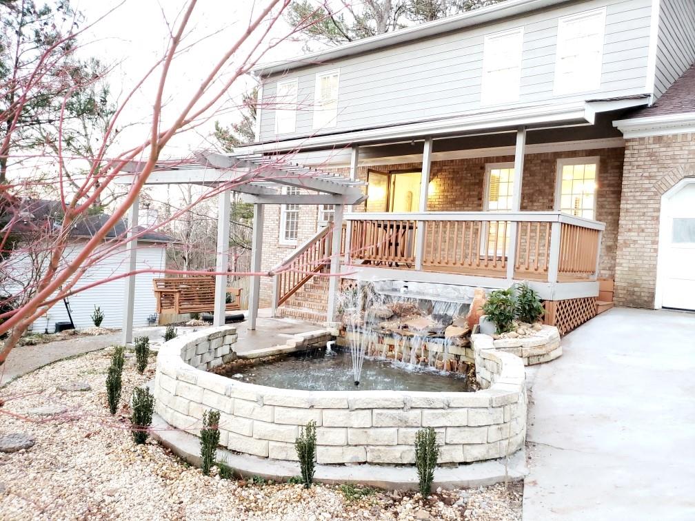 a view of wooden house with large trees and outdoor seating