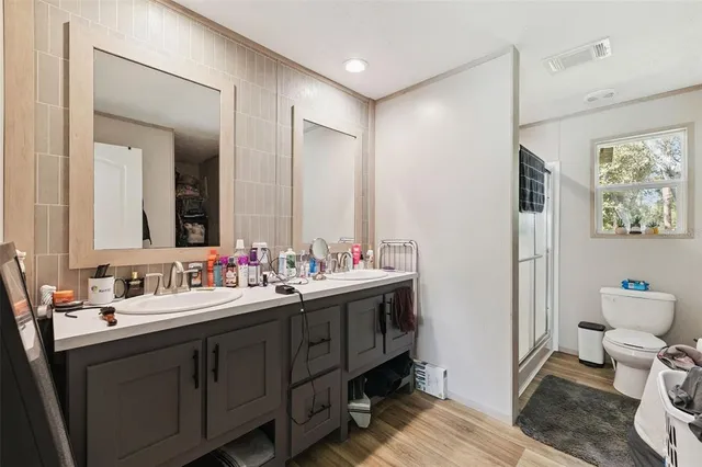 a bathroom with a double vanity sink mirror and toilet