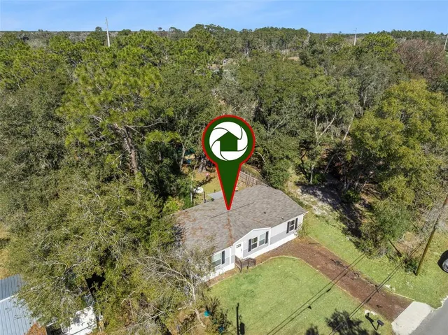 a aerial view of a house with a yard basket ball court and outdoor seating