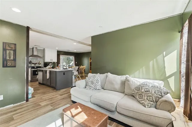a living room with furniture kitchen view and a window