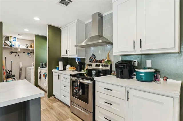 a kitchen with stainless steel appliances granite countertop a sink a stove and a refrigerator