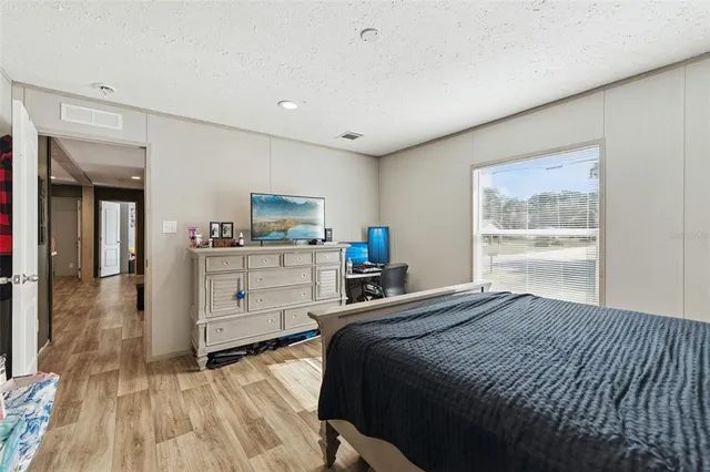 a bedroom with a bed and a view of kitchen