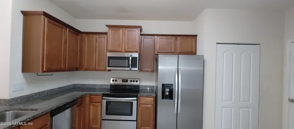a kitchen with a refrigerator stove and microwave