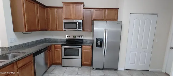 a kitchen with stainless steel appliances granite countertop a refrigerator stove and sink