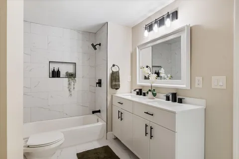 a bathroom with a sink mirror toilet and bathtub