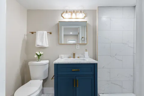 a bathroom with a toilet a sink and mirror