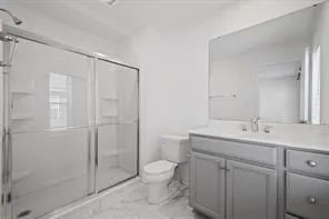 a bathroom with a toilet a sink a mirror and vanity