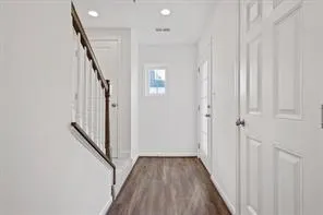 a view of a hallway with wooden floor and staircase