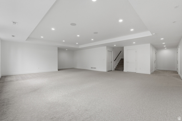 653 East Vandalay Lane Draper, UT 84020 - Photo 32 of 61 Expansive carpeted area featuring recessed lighting, a dropped ceiling detail, white walls, and a staircase with a dark handrail