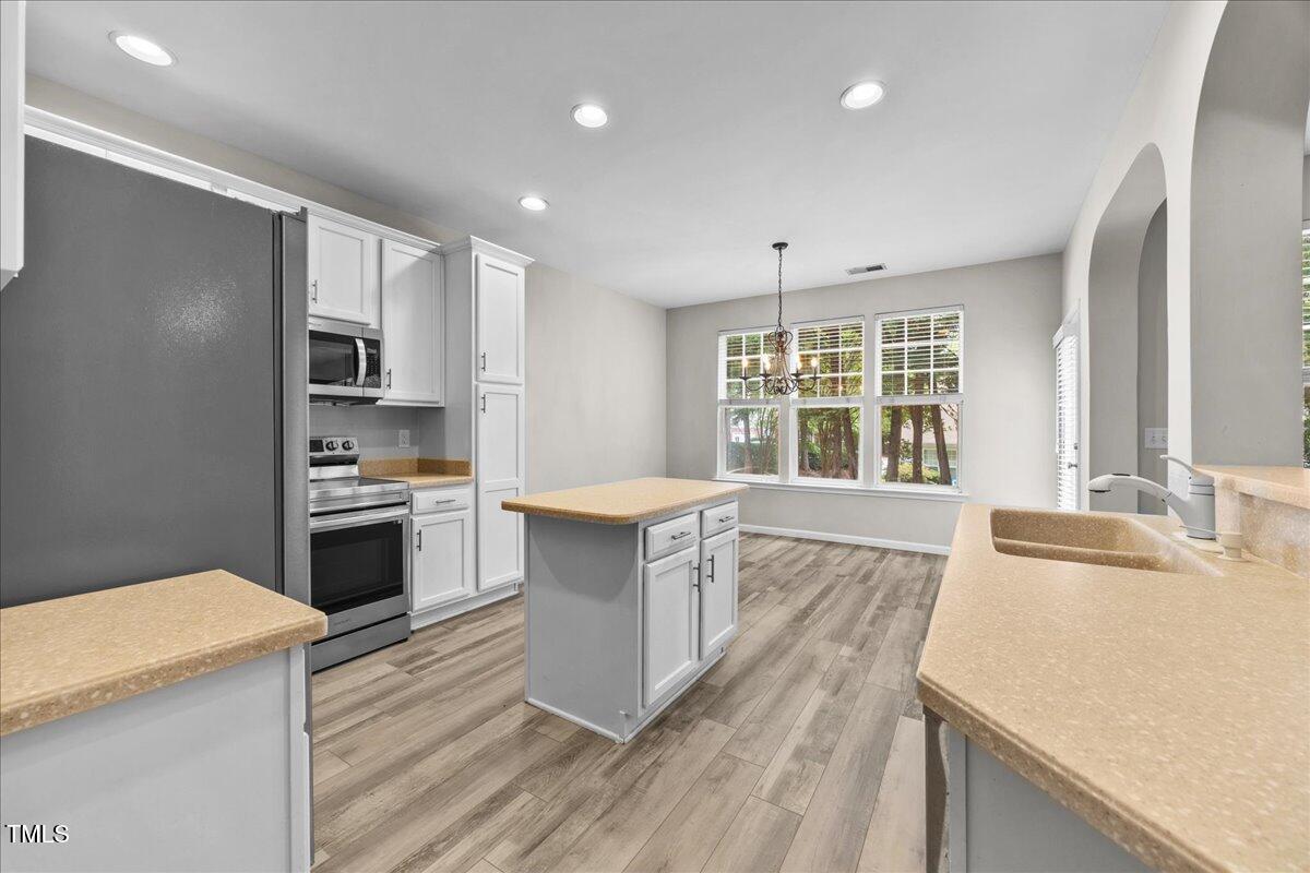 8404 Split Stone Lane Raleigh, NC 27613 - Photo 10 of 45 a kitchen with stainless steel appliances kitchen island granite countertop a stove and a sink