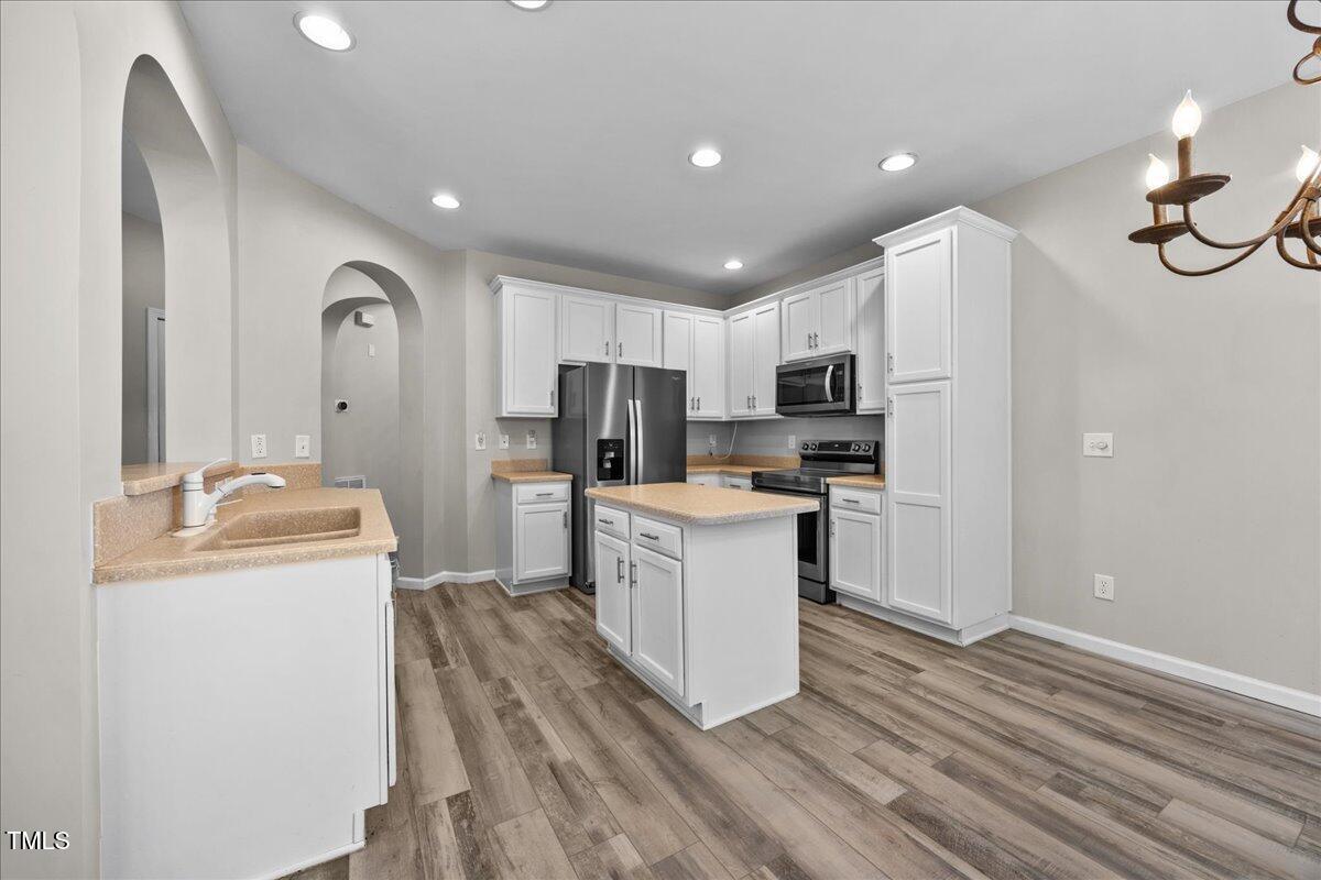 8404 Split Stone Lane Raleigh, NC 27613 - Photo 12 of 45 a kitchen with refrigerator cabinets and wooden floor
