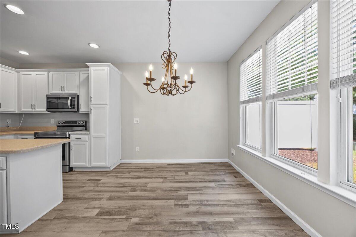 8404 Split Stone Lane Raleigh, NC 27613 - Photo 16 of 45 a view of a kitchen with a sink dishwasher and microwave with wooden floor