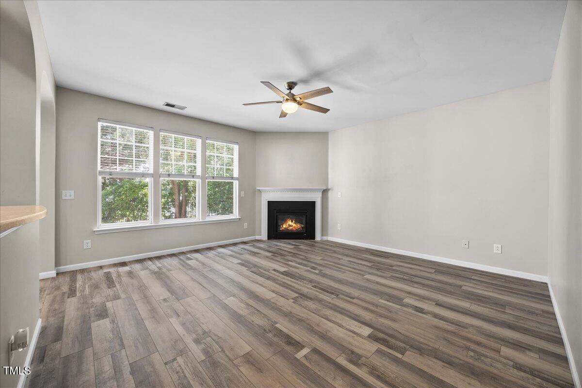 8404 Split Stone Lane Raleigh, NC 27613 - Photo 19 of 45 wooden floor in an empty room with a fireplace
