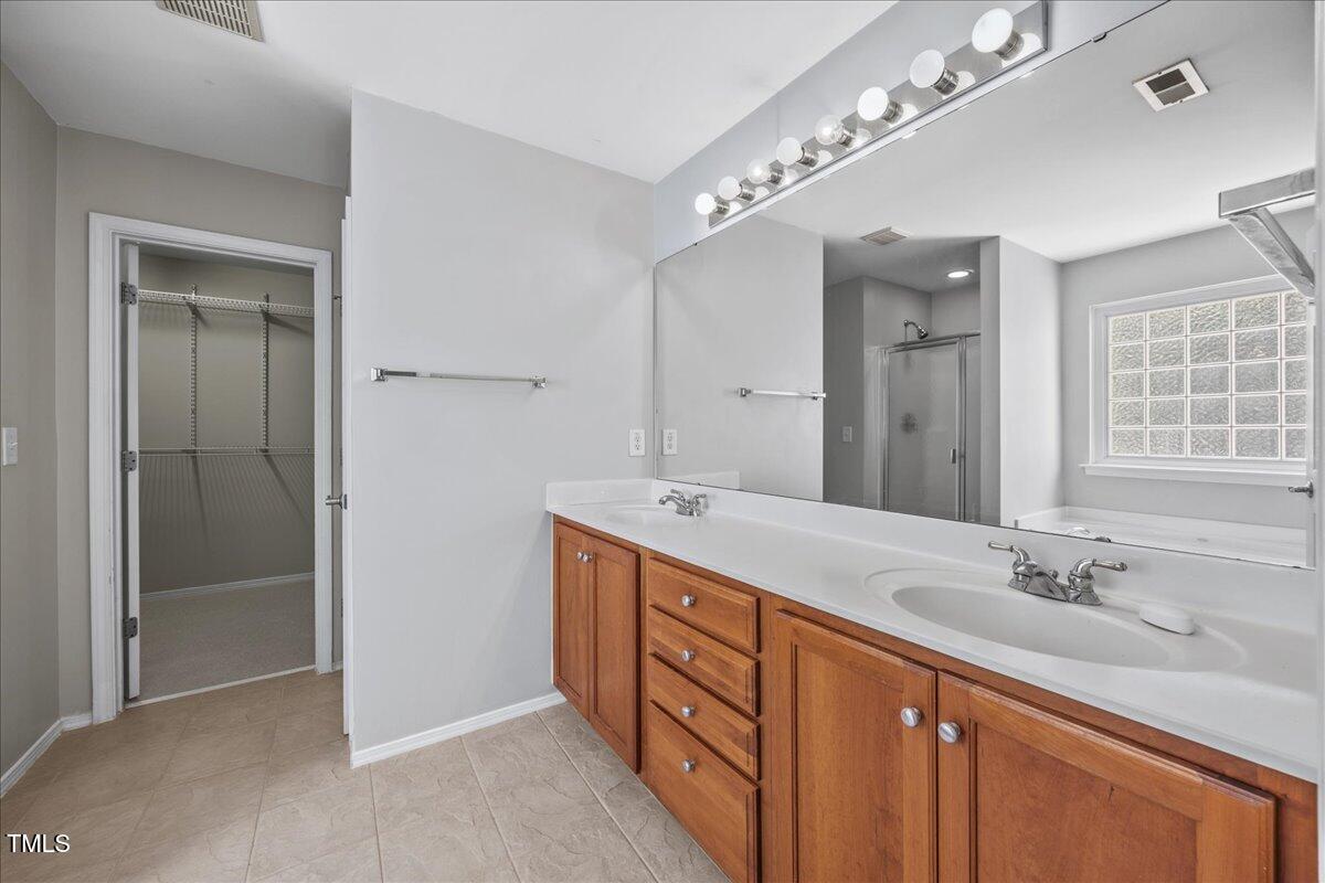 8404 Split Stone Lane Raleigh, NC 27613 - Photo 26 of 45 a spacious bathroom with a double vanity sink mirror and shower
