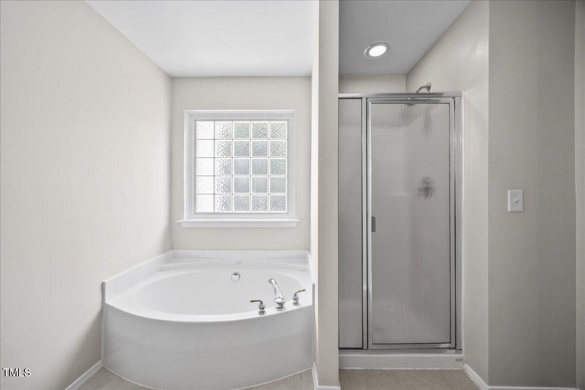 8404 Split Stone Lane Raleigh, NC 27613 - Photo 27 of 45 a white bath tub sitting next to a shower
