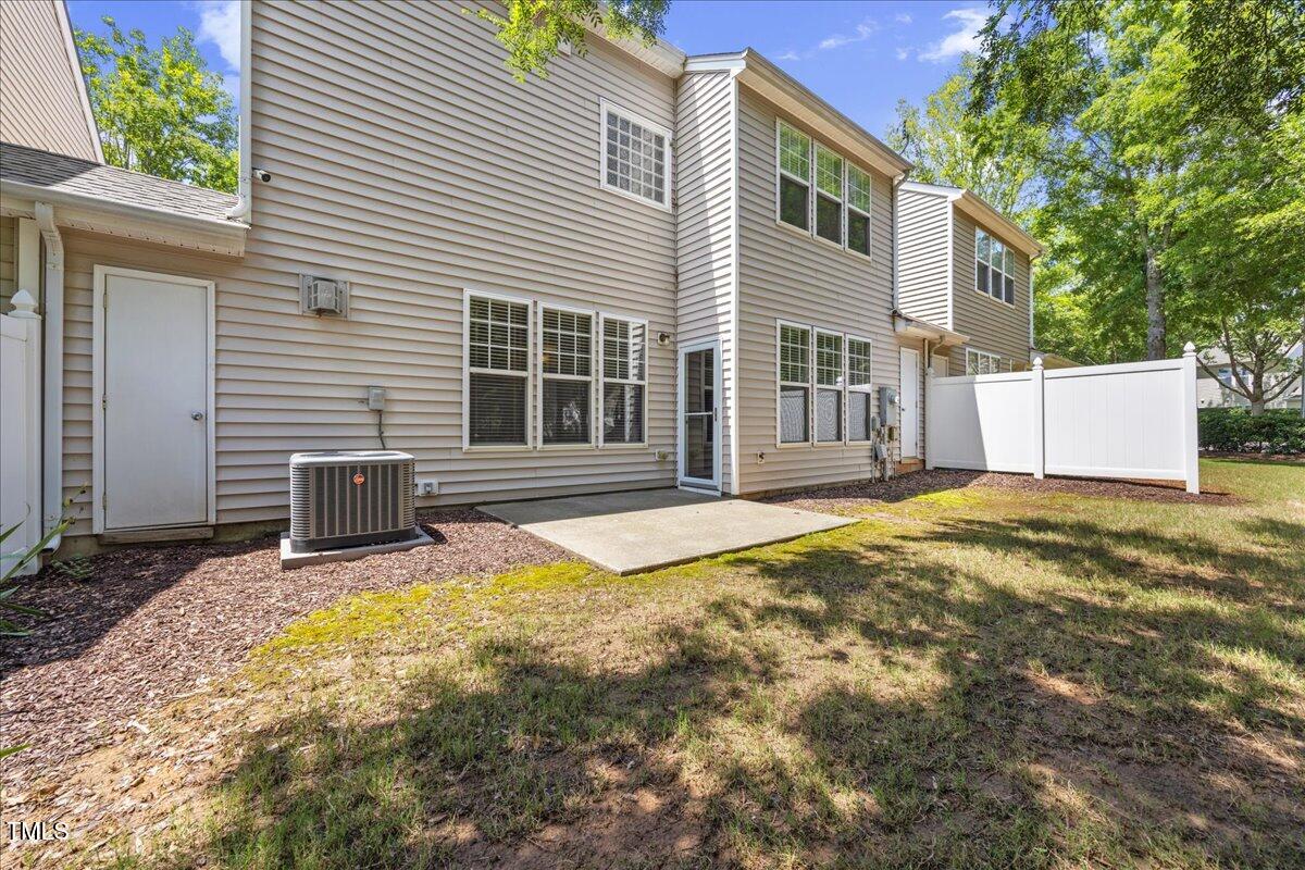 8404 Split Stone Lane Raleigh, NC 27613 - Photo 38 of 45 a house that has a small yard and large trees with wooden fence