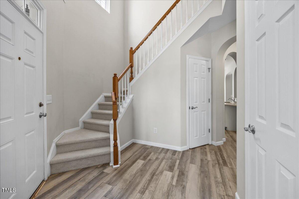 8404 Split Stone Lane Raleigh, NC 27613 - Photo 9 of 45 a view of a hallway with wooden floor and staircase