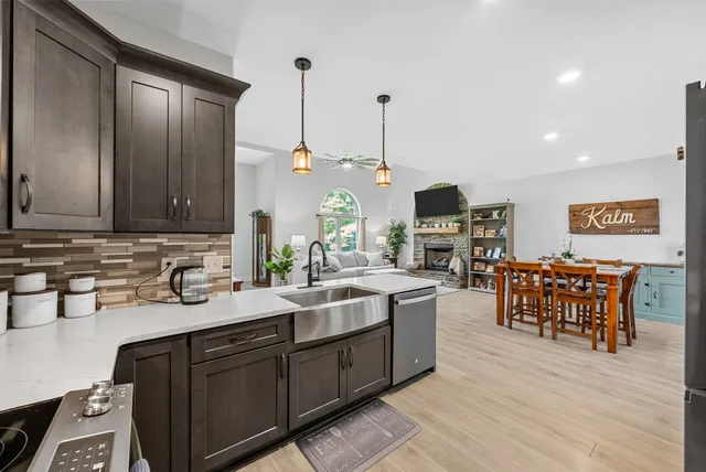 a kitchen with kitchen island granite countertop a sink stainless steel appliances and cabinets