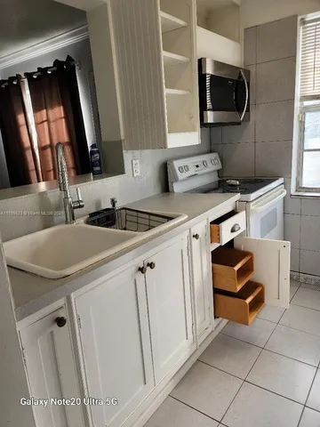 a kitchen with a sink stove and microwave