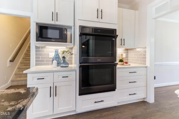 a kitchen with stainless steel appliances granite countertop a refrigerator a stove top oven and a wooden floors
