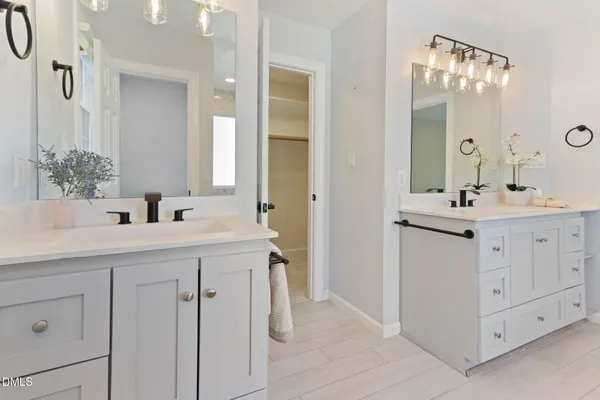 a bathroom with a sink a toilet a mirror and shower