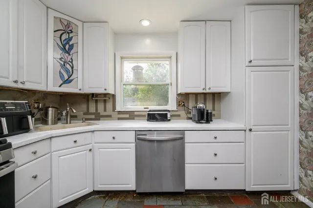 a kitchen with white cabinets and white appliances