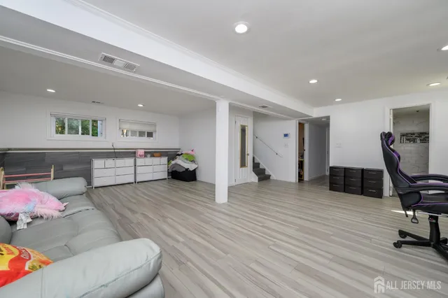 a living room with furniture and a wooden floor