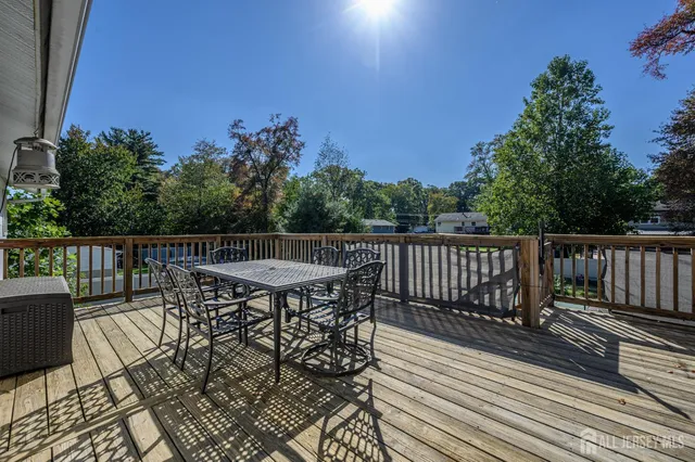 a balcony with wooden floor table and chairs