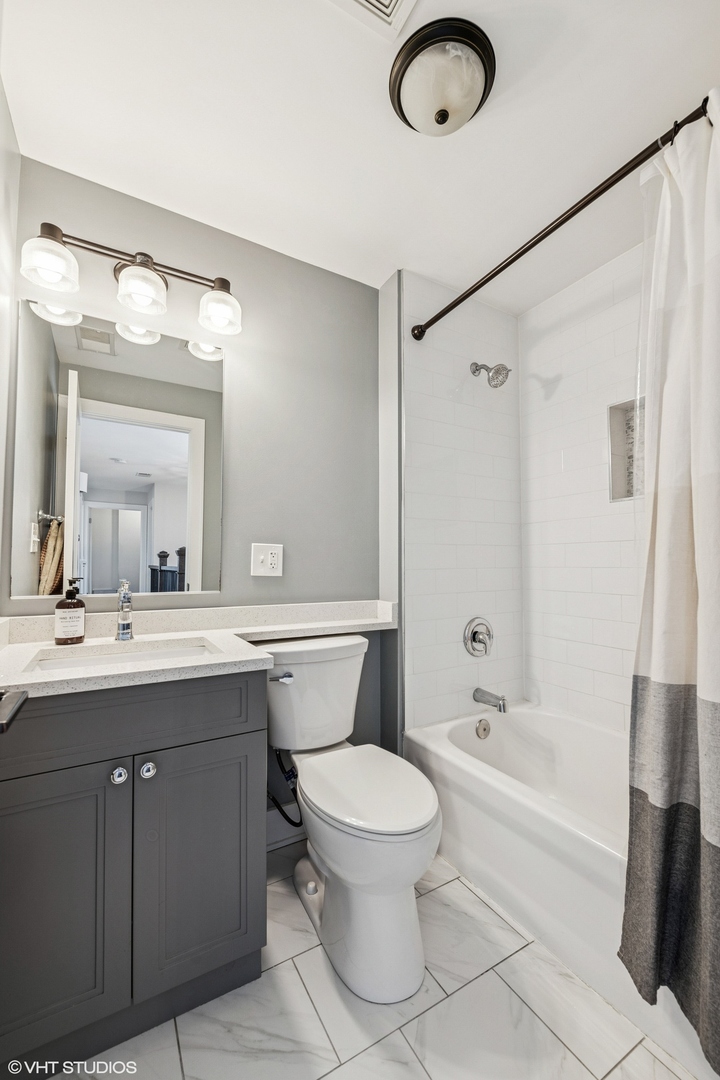 4328 North Ridgeway Avenue Chicago, IL 60618 - Photo 19 of 32 a bathroom with a sink a toilet and a mirror