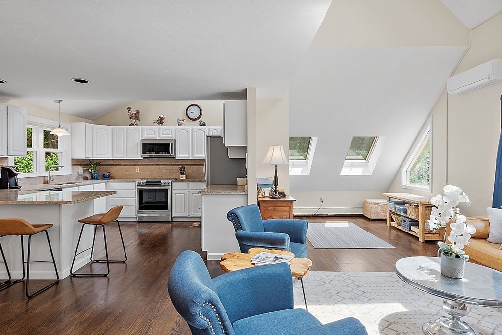 92 Sampson Road Bolton, MA 01740 - Photo 12 of 42 a living room with furniture kitchen view and a wooden floor