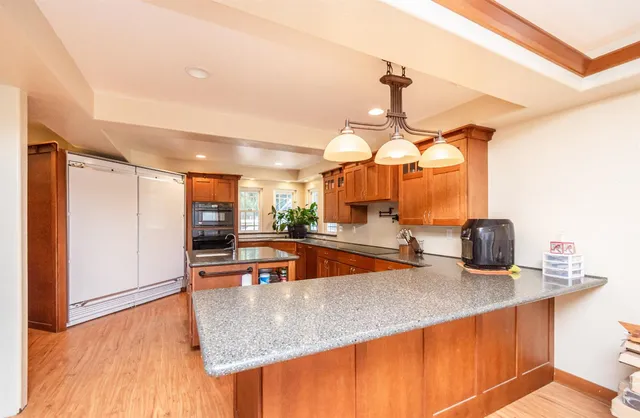 a kitchen with stainless steel appliances granite countertop a sink and a stove