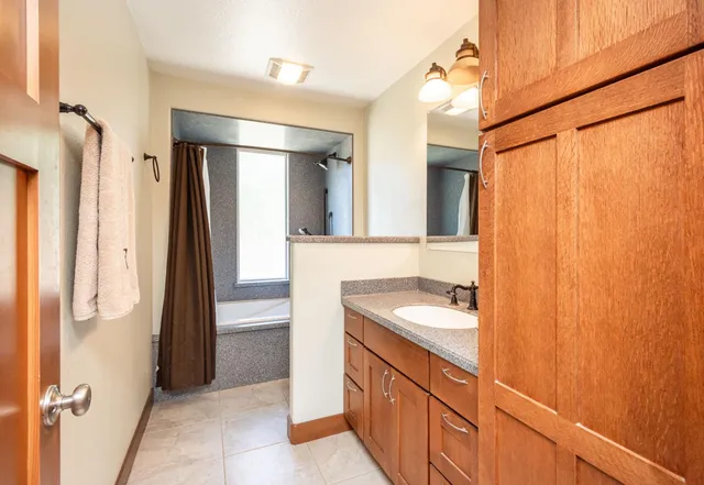 a bedroom with a bed and dresser with mirror