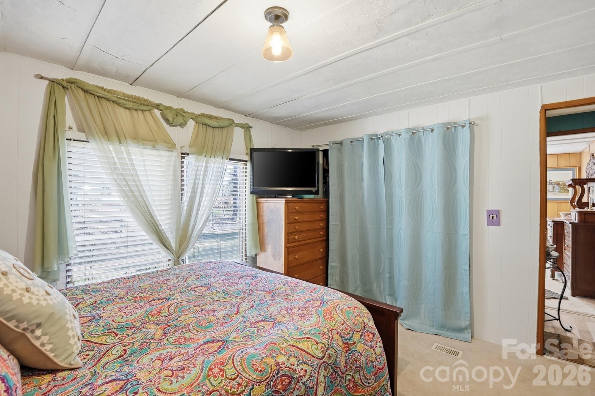 343 Carr Road Dallas, NC 28034 - Photo 17 of 22 a bedroom with a bed closet and a flat tv screen