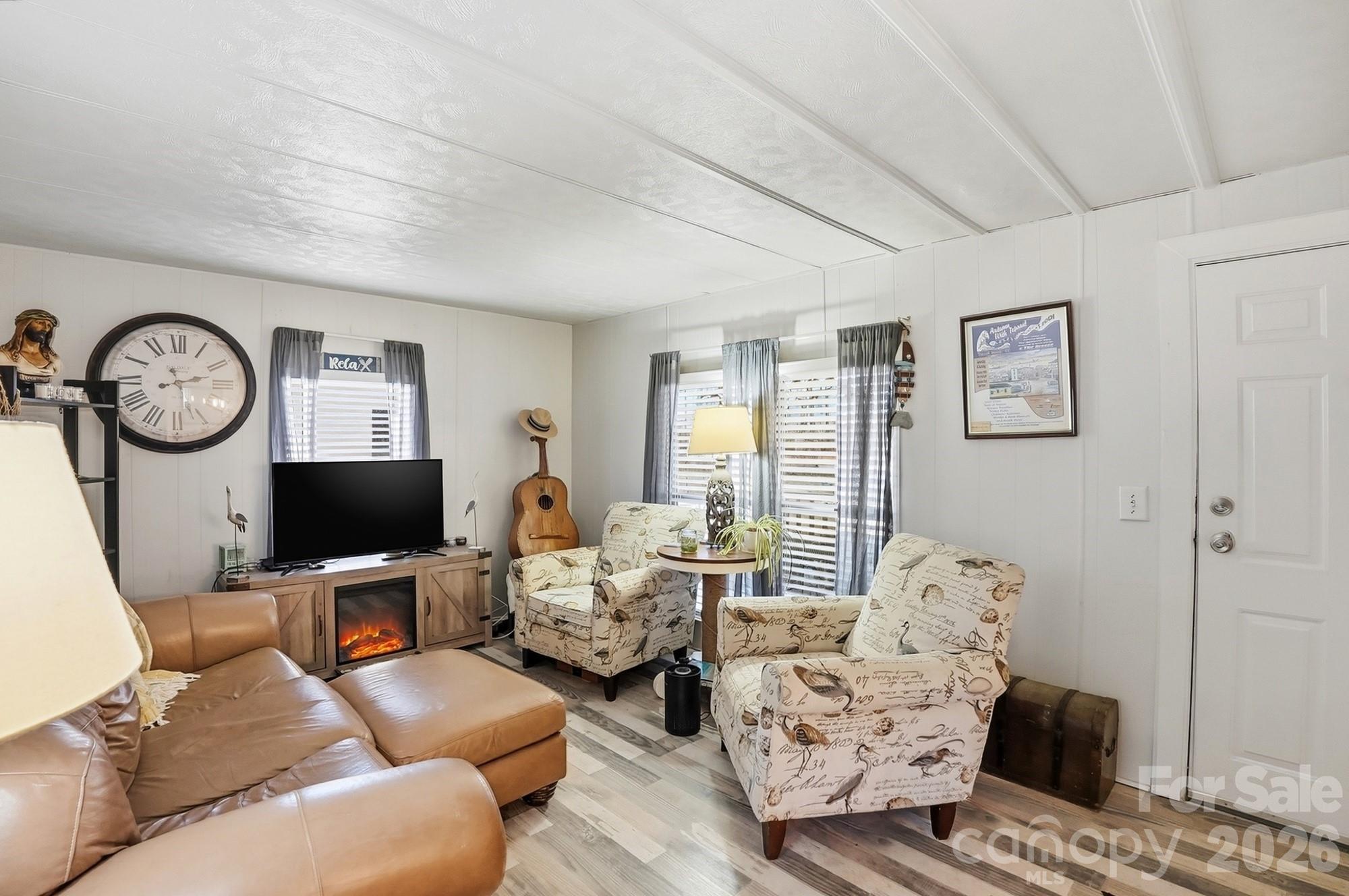 343 Carr Road Dallas, NC 28034 - Photo 5 of 22 a living room with furniture a clock tv and a window