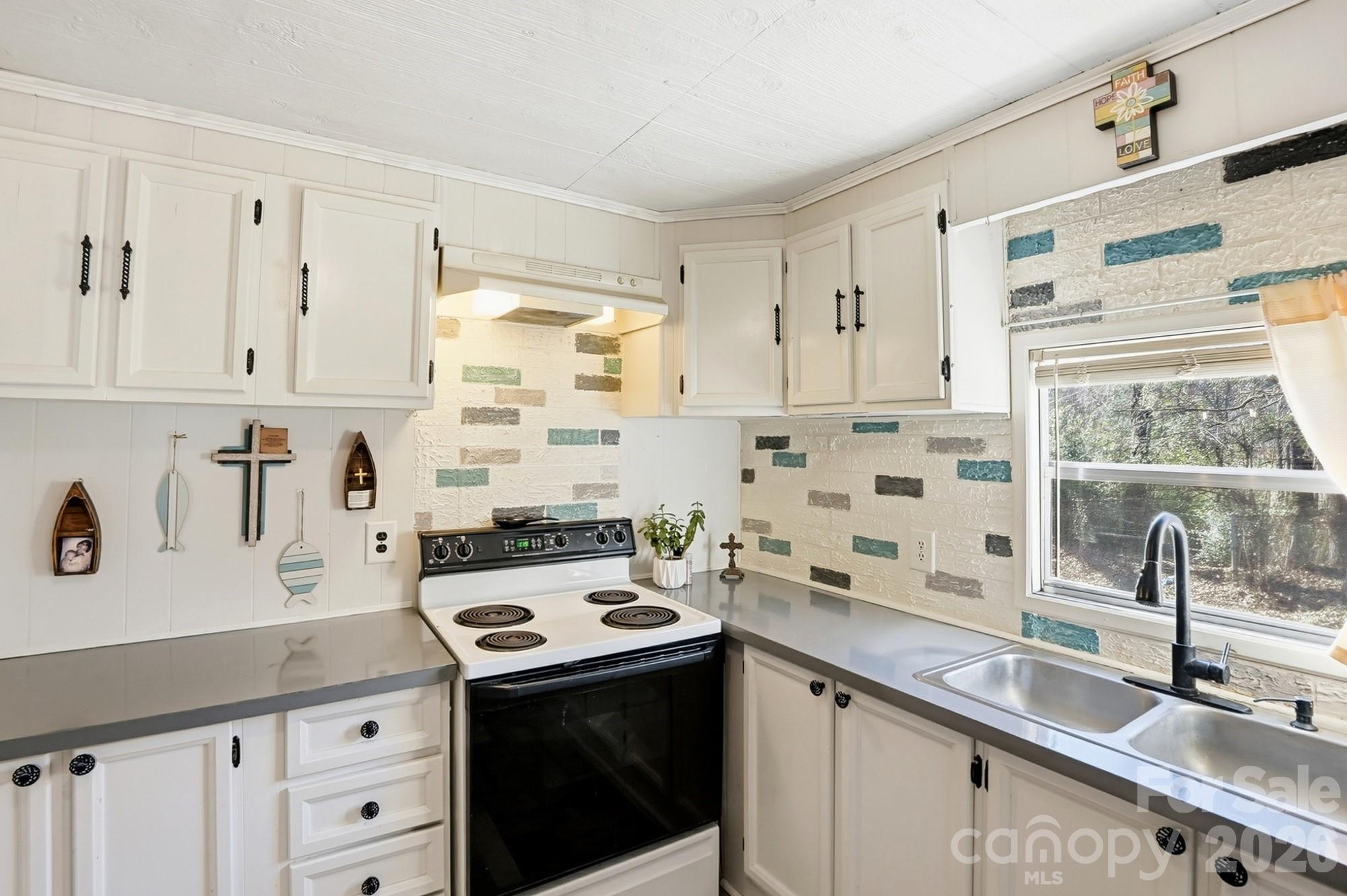 343 Carr Road Dallas, NC 28034 - Photo 9 of 22 a kitchen with white cabinets sink and white appliances