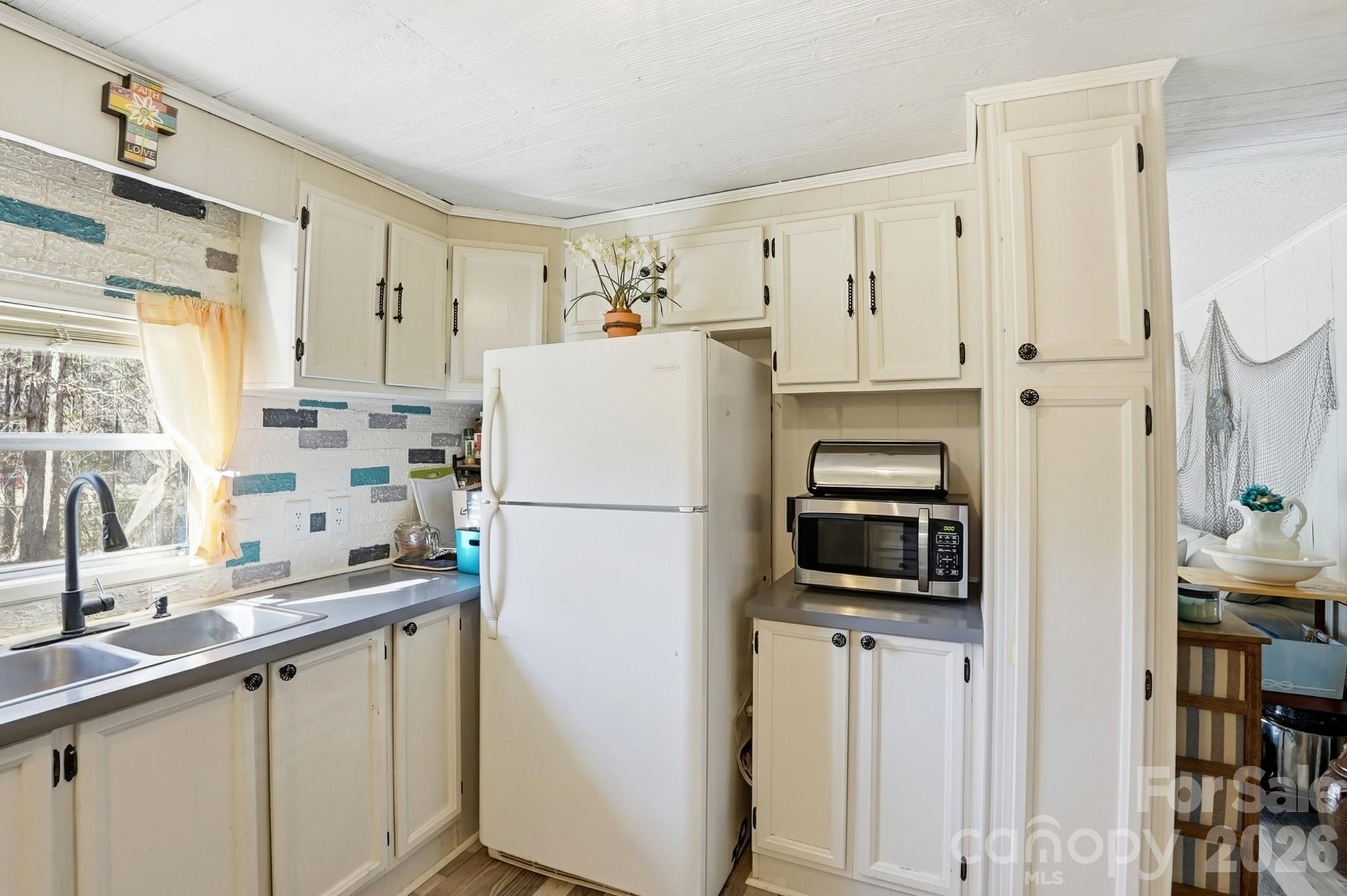 343 Carr Road Dallas, NC 28034 - Photo 10 of 22 a kitchen with a sink a refrigerator and a window