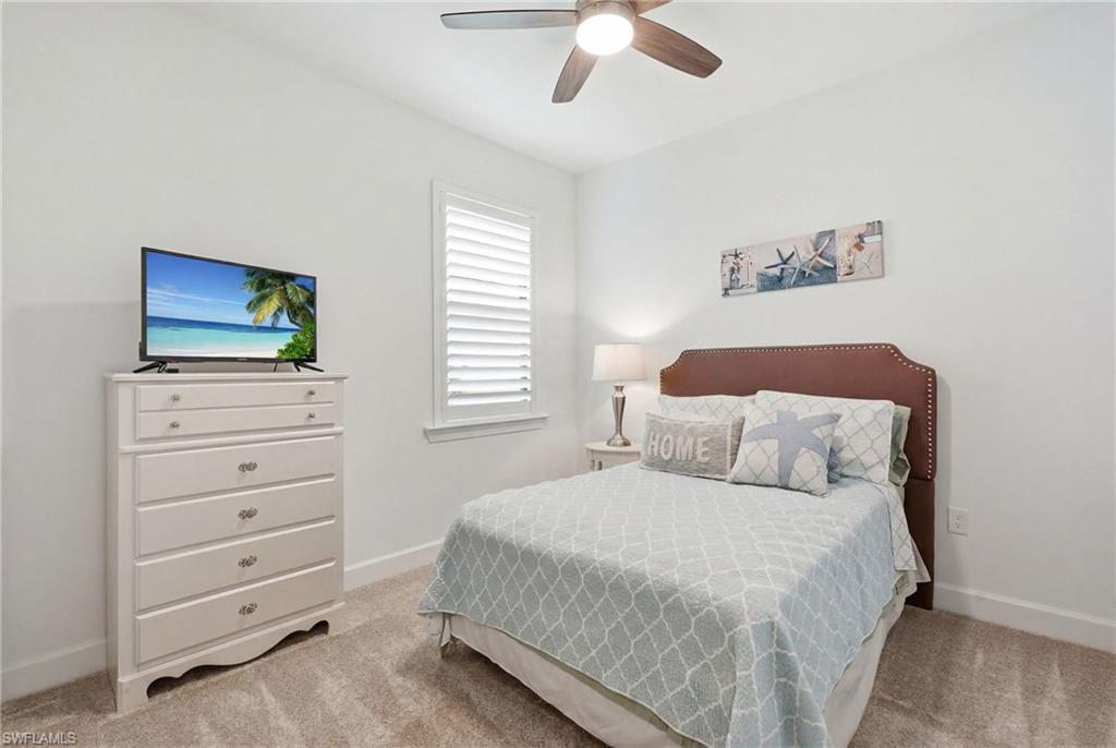 18364 Ridgeline Drive Estero, FL 33928 - Photo 25 of 50 a bedroom with a bed and a flat tv screen on dresser